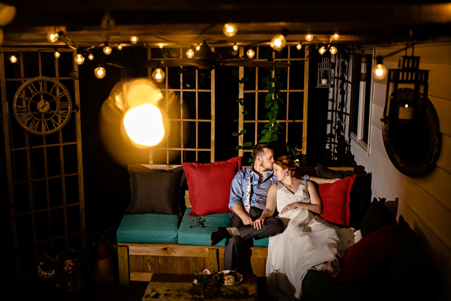 A newly married couple relax and eat cake on their back porch after the wedding day is over.